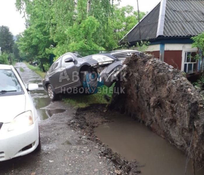 Упавшее дерево приподняло корнями стоящую рядом машину в Кузбассе