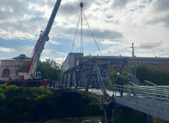 В Новокузнецке установили пролет нового пешеходного моста через Абу